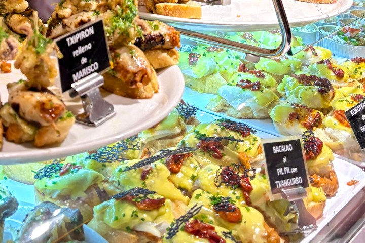Assortment of tapas on display with various toppings on bread.