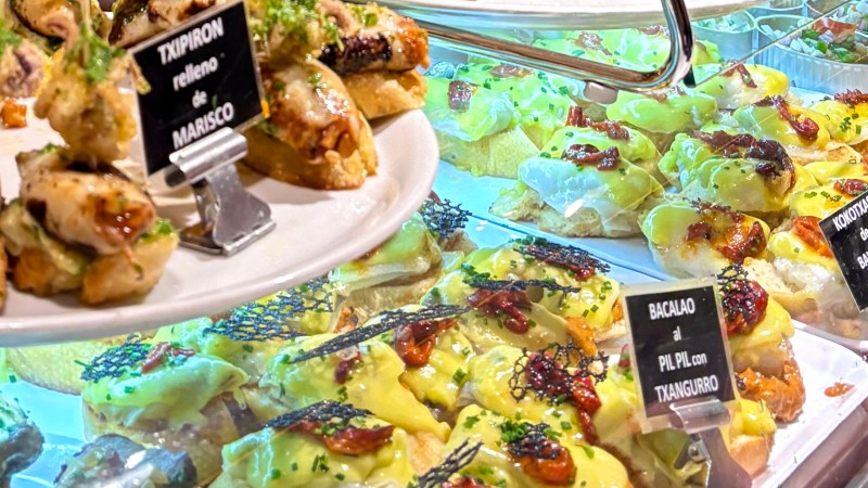 Assortment of tapas on display with various toppings on bread.